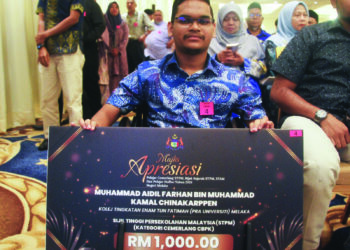 MUHAMMAD Aidil Farhan Muhammad Kamal Bersama replika cek insentif RM1,000 yang diterimanya pada Majlis Apresiasi Pelajar Cemerlang STPM, Bijak Sejarah STPM, STAM dan Pelajar Huffaz 2024 di MITC, Ayer Keroh, Melaka. - UTUSAN/AMRAN MULUP