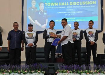 YAHAYA Othman (tengah) menyampaikan cenderahati kepada Timbalan Presiden Majlis Belia Negeri Pahang, Mohamad Suhail Osman pada program Town Hall Discussion Satu Felda, Satu Tekad: Bebas Dadah, Kukuh Muafakat Sempena Kembara Ketua Polis Pahang Tahun 2025 di Dewan Semai Bakti Felda Mempaga 1 di Bentong, Pahang.