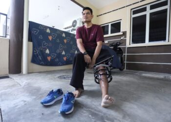 Muhammad Hafies Rosle bersiap bagi menjalani aktiviti fisioterapi harian di rumahnya di Taman Seri Manik, Tanjung Karang. - UTUSAN/AFIQ RAZALI