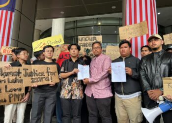 BRANDON Gan (kiri) bersama Azamuddin Sahar menyerahkan memorandum kepada wakil pejabat Menteri Pendidikan, Ahmad Faiz Abdull Rashid selepas mengadakan himpunan di hadapan Kementerian Pendidikan, Putrajaya. - UTUSAN/KAMARIAH KHALIDI