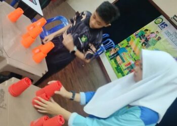 Murid menunjukkan cara permainan stacking cup .