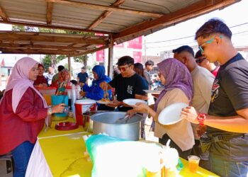 DALIANA Daud (kiri) melayan peserta RXZ Members 7.0 yang singgah menikmati makanan percuma di rumahnya di Kampung Gong Datuk, Kuala Terengganu. - MINGGUAN/ERMA YUSNIDA JUSOH