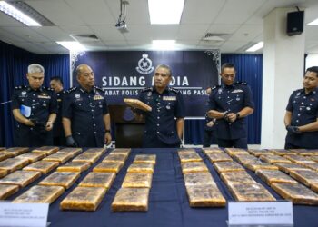 ADZLI Abu Shah (tengah) menunjukkan sebahagian daripada ketulan mampat ganja seberat 93.77kg yang dirampas daripada satu sindiket pengedaran dadah pada sidang akhbar di IPD Kubang Pasu, Jitra di Kubang Pasu. - UTUSAN/SHAHIR NOORDIN