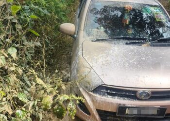 KERETA Perodua Axia yang dipandu pemandu wanita terbenam dalam lumpur selepas tersesat di kawasan ladang kelapa sawit di Alor Gajah, Melaka.