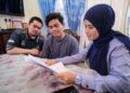 MUHD. IMRAN Zakaria (tengah) bersama abangnya, Muhd. Akram (kiri) menerima faedah Pencen Penakat yang disampaikan oleh wakil Perkeso di kediaman mereka di Kampung Melayu, Batu Caves, Selayang, hari ini.