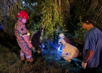 ANGGOTA bomba membawa keluar mayat lelaki OKU dari dalam longkang selepas motosikal ditunggang terbabas di Pekan Lambor Kanan, Seri Iskandar. - UTUSAN/IHSAN JBPM