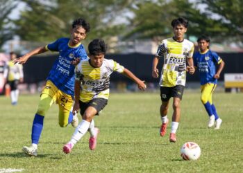 PEMAIN Perak, Ahmad Daniel Hakimi (depan) melepasi asakan pemain Perlis pada perlawanan Liga A1 Semi -Pro di Kompleks Bola Sepak Perak Chepor di Ipoh kelmarin. - UTUSAN/MUHAMAD NAZREEN SYAH MUSTHAFA
