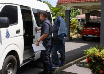 TERTUDUH Azhar Mat Saini dikawal anggota polis ketika dihadapkan ke mahkamah atas pertuduhan memandu secara berbahaya di Mahkamah Majistret Gurun. - UTUSAN/ SHAHIR NOORDIN