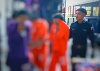 SUSPEK memakai baju lokap berwarna oren semasa tiba di Mahkamah Majistret, Kota Bharu, Kelantan. - UTUSAN/KAMARUL BISMI KAMARUZAMAN