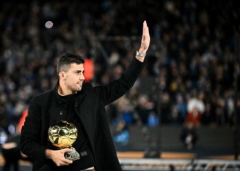 Pemain tengah Manchester City, Rodri melambai kepada peminat ketika dia memasuki padang dengan anugerah Ballon d'Or 2024 yang diterimanya pada 28 Oktober tahun lalu sebelum bermulanya perlawanan bola sepak Liga Perdana Inggeris antara Manchester City dan Tottenham Hotspur di Stadium Etihad di Manchester, November lalu. - AFP