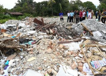 SANDREA Ng Shy Ching meninjau timbunan sisa bahan binaan yang menimbus kolam tadahan menyebabkan sistem saliran terjejas di Kampung Pasir Puteh  di Ipoh. - UTUSAN/MUHAMAD NAZREEN SYAH MUSTHAFA