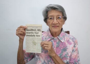 P. Savithri menunjukkan kerata akhbar ketika dia cuba mendapatkan semula pingatnya. - Ihsan MA