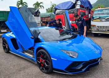 PEGAWAI Jabatan Pengangkutan Jalan (JPJ) Terengganu melakukan pemeriksaan ke atas sebuah kenderaan mewah yang disita dalam Op Luxury di Depoh Sita JPJ Negeri Terengganu. - UTUSAN/PUQTRA HAIRRY