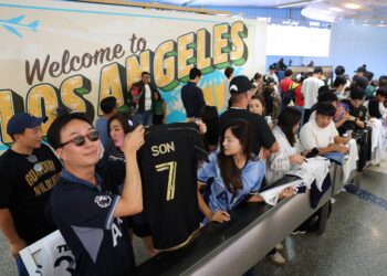 Penyokong pemain bola sepak Korea Selatan Son Heung-min menunggu ketibaannya di Lapangan Terbang Antarabangsa Los Angeles (LAX) di Los Angeles, California, hari ini. - AFP