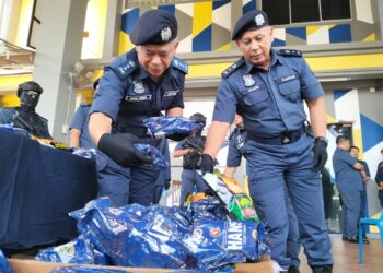 WAN Jamal Abdul Salam Wan Long (kiri) memeriksa tembakau kunyah yang dirampas semasa sidang akhbar di Cawangan Penguatkuasa JKDM Rantau Panjang, Kelantan hari ini. - UTUSAN/ROHANA ISMAIL