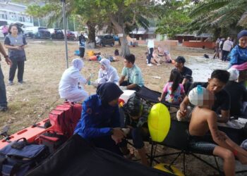 PESERTA renang yang terkena sengatan ubur-ubur diberikan rawatan di Pantai Teluk Senangin dekat Lumut semalam.