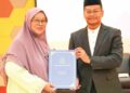 Ahmad Khirrizal Ab. Rahman menyampaikan surat kenaikan pangkat secara khas untuk penyandang kepada Sariah Mohamad Arshad di Pekan baru-baru ini.