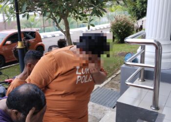 SUSPEK (baju jingga) dibawa ke Kompleks Mahkamah, Alor Gajah, Melaka bagi permohonan reman selepas disyaki merotan seorang murid sehingga lebam. - UTUSAN/MUHAMMAD SHAHIZAM TAZALI