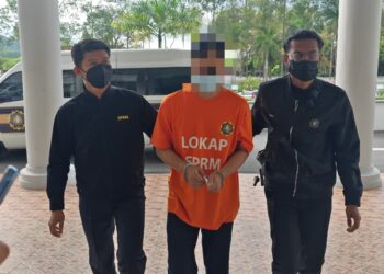 SUSPEK diiringi pegawai SPRM direman sehingga 7 September ini selepas disyaki menyalahgunakan wang persatuan sebanyak RM84,500 bagi membayar kos guaman dan perintah mahkamah isterinya. - UTUSAN/AMRAN ALI