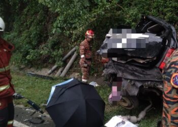 Pasukan bomba menjalankan kerja-kerja mengeluarkan mangsa yang tersepit di dalam kenderaan Toyota Wish. GAMBAR/IHSAN BBP KOTA KINABALU