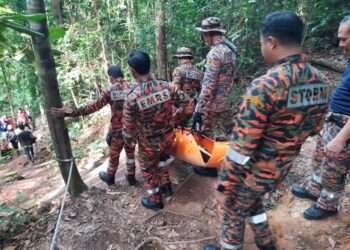 ANGGOTA Bomba membawa turun seorang remaja perempuan yang kepenatan dan hampir pengsan ketika mendaki Gunung Lambak, Kluang, Johor.