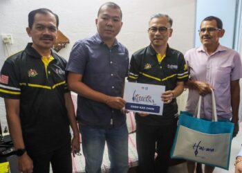 FAHMI Fadzil (dua dari kanan) ketika menyampaikan bantuan Tabung Kasih@HAWANA kepada Choo Kar Chun di Bandar Baru Air Itam, George Town, Pulau Pinang hari ini. - UTUSAN/DANIAL SAAD