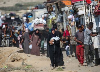 RAKYAT Palestin yang dipindahkan bergerak ke selatan melalui jalan di kawasan kem pelarian Nuseirat, di tengah Gaza, susulan arahan pemindahan tentera Israel.- AFP