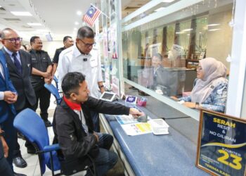 SAIFUDDIN Nasution Ismail meninjau operasi penggantian cip MyKad percuma di kaunter Jabatan Pendaftaran Negara Putrajaya, semalam. – UTUSAN/FAISOL MUSTAFA