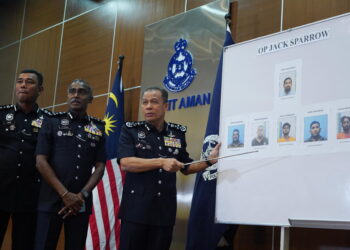 MOHD. Khalid Ismail menunjukkan gambar-gambar orang yang dikehendaki dalam sidang akhbar tangkapan Op Jack Sparrow di Ibu Pejabat Polis Bukit Aman, Kuala Lumpur hari ini. - UTUSAN/FAUZI BAHARUDIN