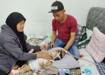 MOHD. HANAFI Musa dan Zuraidah Hassan bersama anak mereka Puteri Balqis ketika ditemui rumah mereka di Lorong Haji Nasir, Api-Api, Parit 4, Pontian, Johor.