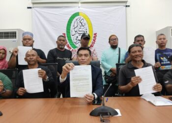 MOHD. NIZAM Ithnin (duduk, kiri) bersama peguam persatuan, Sheikh Ikhzan Sheikh Salleh (duduk, tengah) menunjukkan notis penyusunan peniaga sepanjang Jalan Pantai Puteri daripada MBMB ketika sidang akhbar di Klebang, Melaka. - UTUSAN/ MUHAMMAD SHAHIZAM TAZALI