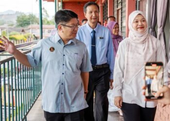 EWON Benedick (kiri) mengiringi Fadhlina (kanan) melawat SMK Limbanak, Penampang yang terjejas banjir sebelum ini. - HARDY JOE