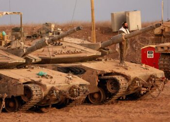 SEORANG askar berdoa di atas kereta kebal tentera Israel yang ditempatkan berhampiran sempadan Semenanjung Gaza. – AFP