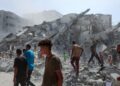 PENDUDUK Palestin mencari mangsa di celah runtuhan Menara al-Ghafari yang musnah akibat bedilan Israel di Gaza City.-AFP