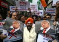 AHLI persatuan perdagangan memegang poster Donald Trump sambil melaungkan slogan membantah kenaikan tarif terbaharu AS terhadap India di New Delhi.-AFP
