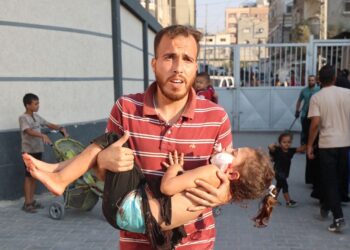 SEORANG lelaki Palestin membawa seorang kanak-kanak perempuan yang cedera ke Hospital al-Awda di tengah Semenanjung Gaza.-AFP