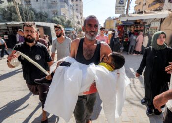 SEORANG lelaki membawa mayat kanak-kanak yang terbunuh dalam pengeboman Israel di al-Bureij di Nuseirat, tengah Gaza, pada Ahad lalu.– AFP