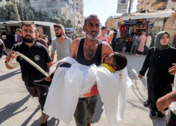 SEORANG lelaki membawa mayat kanak-kanak yang terbunuh dalam pengeboman Israel di al-Bureij di Nuseirat, tengah Gaza, pada Ahad lalu.– AFP