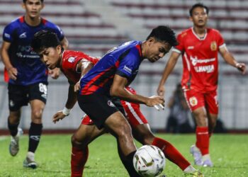Pemain PDRM, Amir Saiful Badeli (depan), diasak pemain Kelantan TRW, pada perlawanan Liga Super Stadium Majlis Perbandaran Selayang, kelmarin.- UTUSAN/SHIDDIEQIIN ZON