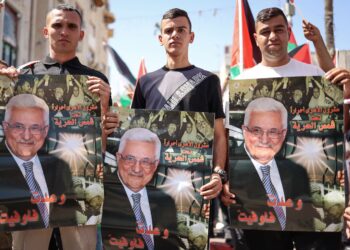 PENDUDUK Palestin memegang poster wajah Mahmoud Abbas ketika menyertai perhimpunan  menyokong Presiden PA serta pengiktirafan negara Palestin di Ramallah, Tebing Barat.-AFP