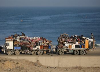 PENDUDUK Palestin yang dipindahkan bergerak menuju ke selatan melalui jalan di kawasan kem pelarian Nuseirat, di tengah Gaza, kelmarin.- AFP