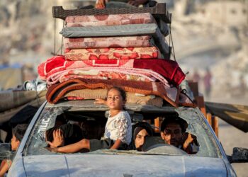 SEORANG kanak-kanak perempuan duduk di bahagian hadapan sebuah kenderaan membawa beberapa penduduk serta barangan mereka ketika berpindah menuju ke selatan Gaza.-AFP