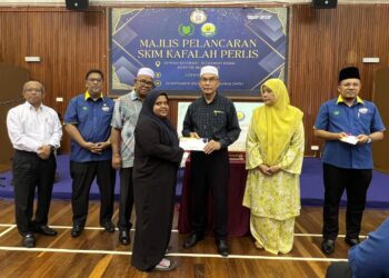 MOHD. Shukri Ramli (tiga dari kanan) menyerahkan sumbangan kepada salah seorang penerima pada Majlis Pelancaran Skim Kafalah Perlis di Dewan Residensi Kediaman Rasmi Menteri Besar, Kangar, Perlis hari ini. -UTUSAN/ASYRAF MUHAMMAD