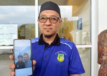 KHAIROL Rizal Mustafar, 42, menunjukkan gambar kenangannya dengan anak lelakinya, Abdul Fatah ketika ditemui pemberita di Unit Perubatan Forensik Hospital Rembau, hari ini.-GAMBAR/NOR AINNA HAMZAH