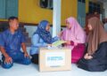 SUHARA Mustaffa (dua dari kiri) menyampaikan bantuan Perkeso kepada Nur Nabilah Abdul Rahim (dua dari kanan) dan kakaknya, Nur Nadhirah di Kampung Pulau Kerengga, Marang, Terengganu. 
– UTUSAN/PUQTRA HAIRRY