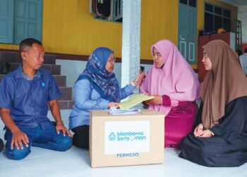 SUHARA Mustaffa (dua dari kiri) menyampaikan bantuan Perkeso kepada Nur Nabilah Abdul Rahim (dua dari kanan) dan kakaknya, Nur Nadhirah di Kampung Pulau Kerengga, Marang, Terengganu. 
– UTUSAN/PUQTRA HAIRRY