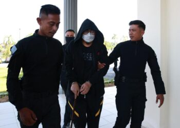MOHAMAD Aswadi Yah (bergari) ketika dibawa ke Mahkamah Sesyen Pasir Mas, Kelantan, semalam. – UTUSAN/KAMARUL BISMI KAMARUZAMAN