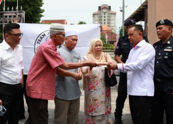 WAN Abdul Rahman  Wan Yaacob menyerahkan memorandum kepada Anas Rizuan Shamsuddin di pekarangan Kompleks Kota Darul Naim, Kota Bharu, Kelantan semalam. – UTUSAN/KAMARUL BISMI KAMARUZAMAN