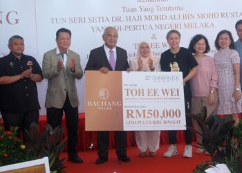 MOHD Ali Mohd. Rustam menyampaikan replika cek bernilai RM50,000 kepada Toh Ee Wei pada jamuan petang di Bachang Villa, Melaka.-UTUSAN/AMRAN MULUP