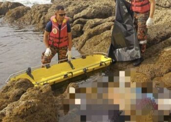 ANGGOTA penyelamat JBPM membawa mayat mangsa yang terdampar di Pantai Kelambu , Kudat semalam. - GAMBAR/IHSAN JBPM